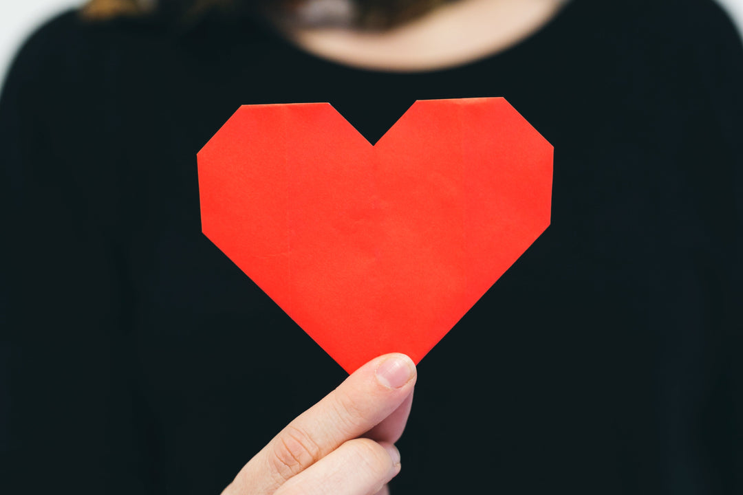 Hand holding an origami heart