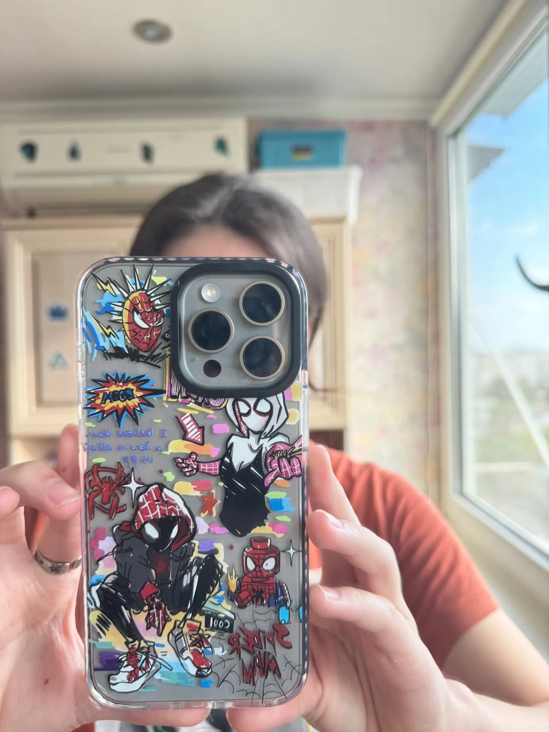 A transparent phone case with a colorful Spider-Verse design