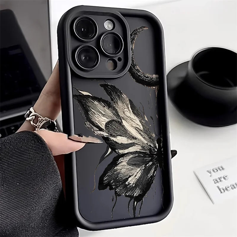 Photo of a hand holding a black phone case with a butterfly design