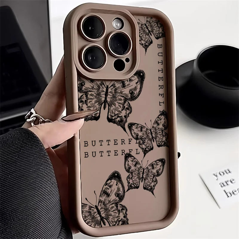 Photo of a hand holding a brown phone case with a butterfly design.