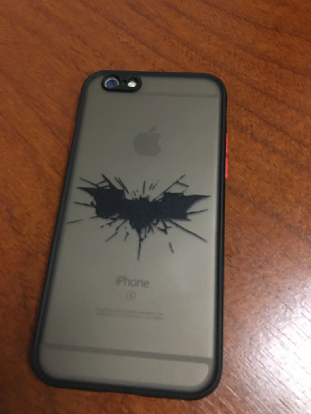 Phone case featuring a cracked Batman symbol