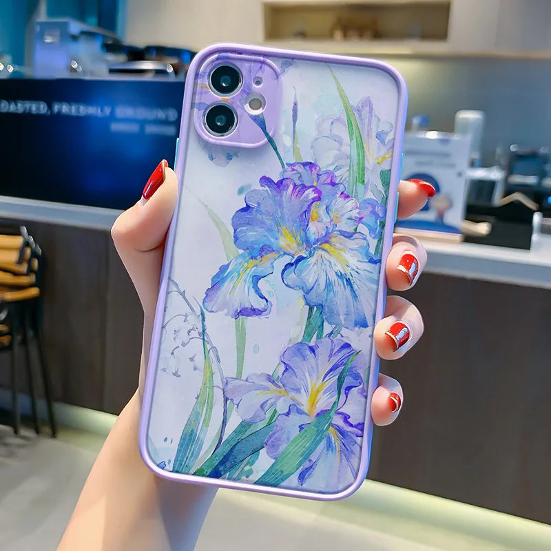 A close-up photo of a hand holding a frosted phone case with a watercolor painting of purple irises