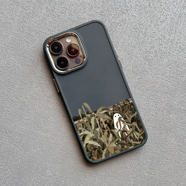 A dark gray phone case with a white ghost standing in a field of tall grass. 