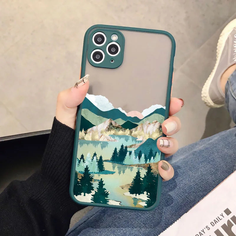 A green phone case with a frosted back showing a serene landscape with mountains, a lake, and a forest