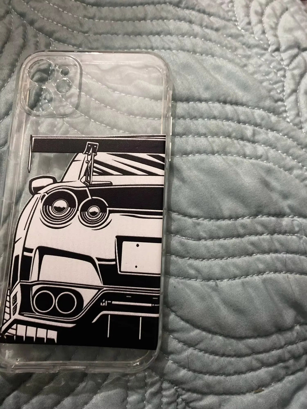 Introducing the GT-R for iPhone: a sleek and clear phone case featuring a stunning black-and-white illustration of a Nissan GT-R rear on a quilted fabric background, designed with an anti-scratch surface to ensure lasting protection.