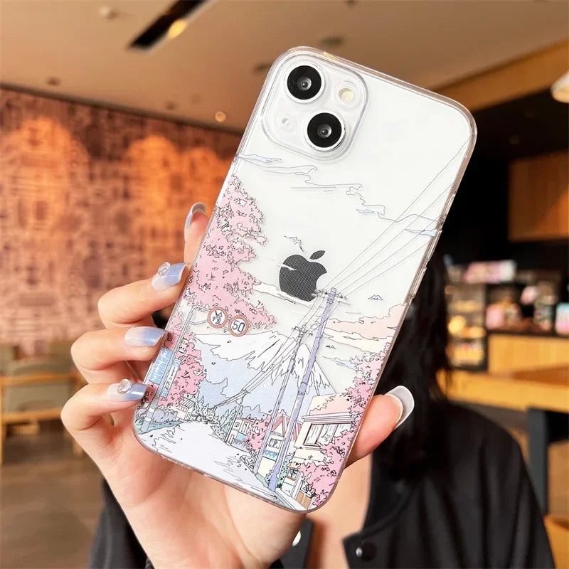 A clear phone case with a cherry blossoms and mountain scene depicted on the back