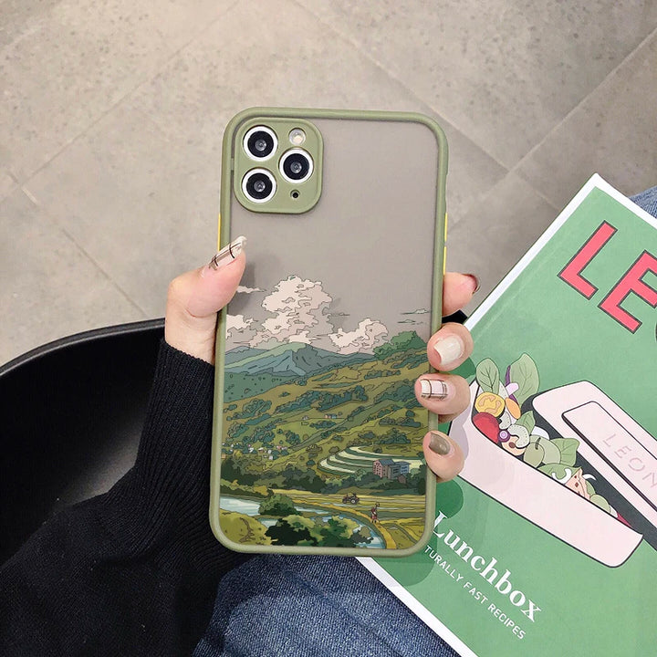 A green phone case with a frosted back featuring a landscape painting of rolling hills, a village, and a road