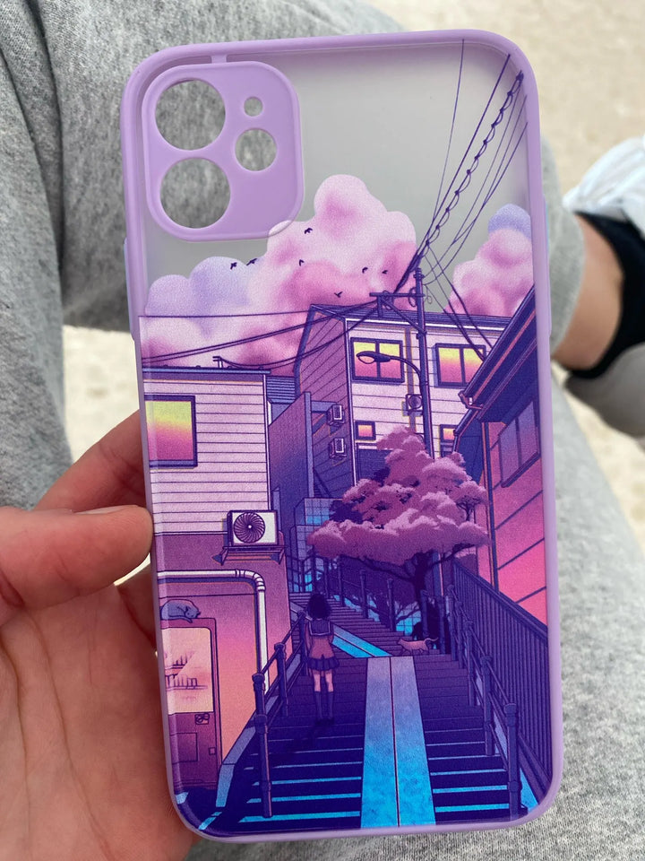 A purple phone case with a frosted back showing a dreamy cityscape with pastel-colored clouds, a staircase leading up to a building, and power lines