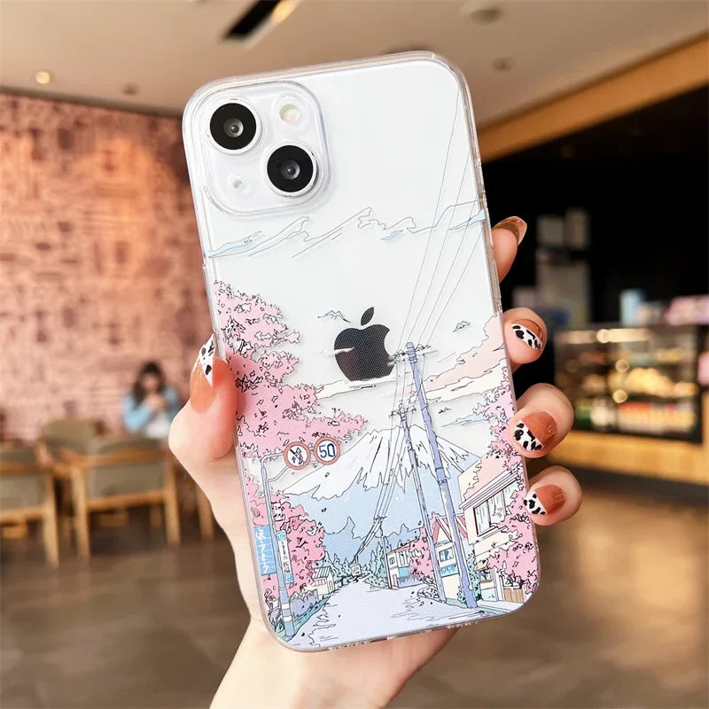 A clear phone case with a cherry blossoms and mountain scene depicted on the back