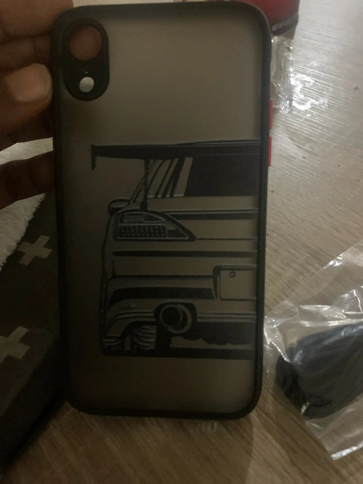 A person holding the JDM Frosted for iPhone TPU phone case, which has a matte finish and features an illustration of a car's rear end complete with a spoiler, taillight, and exhaust.