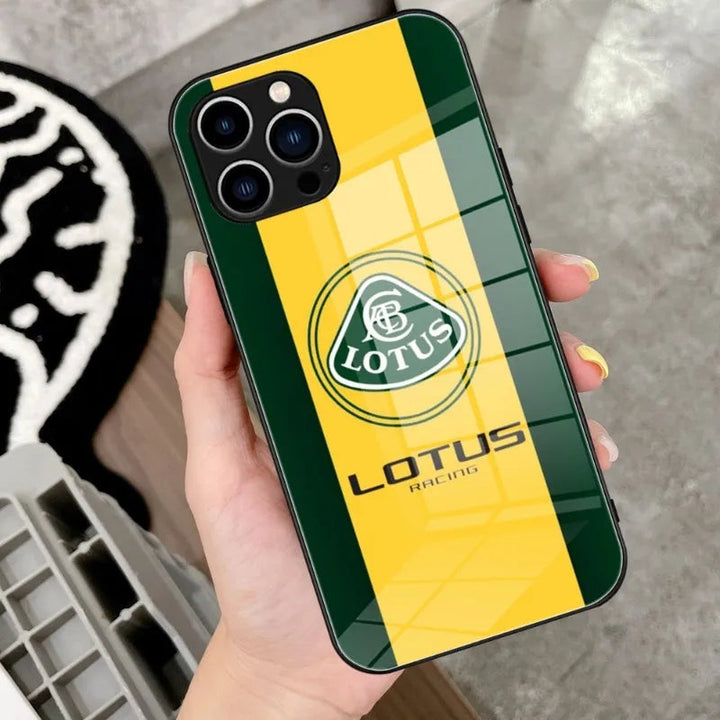 A person holds a sleek Lotus Glass for iPhone case, featuring the Lotus Racing logo and green and yellow stripes.