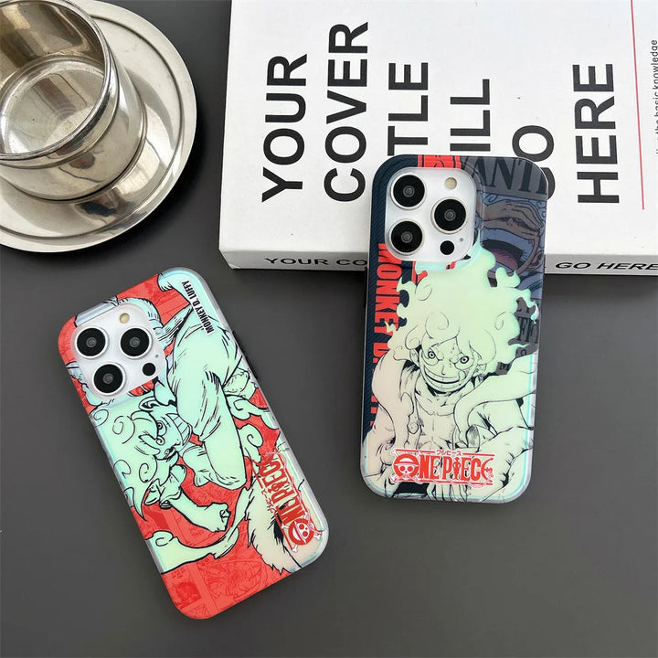 Two smartphones with "One Piece" themed cases, including the Luffy Gradient for iPhone case featuring Luffy, sit on a table next to a metallic cup and a white box partially covered with text. The cases not only showcase your fandom but also offer anti-scratch protection.