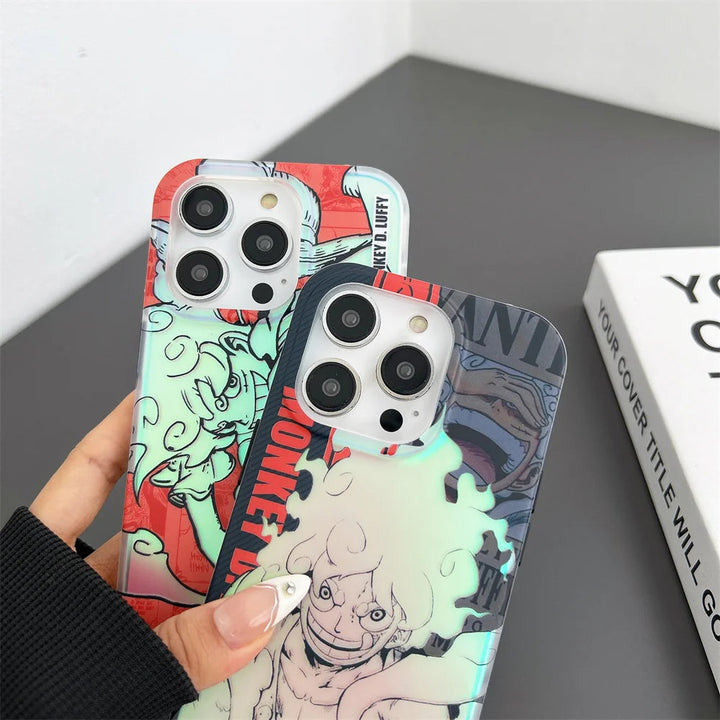 Two hands holding iPhones with Luffy Gradient for iPhone cases, featuring vibrant red and blue designs with Monkey D. Luffy from One Piece. The anti-scratch cases showcase character images and are set against a gray surface.