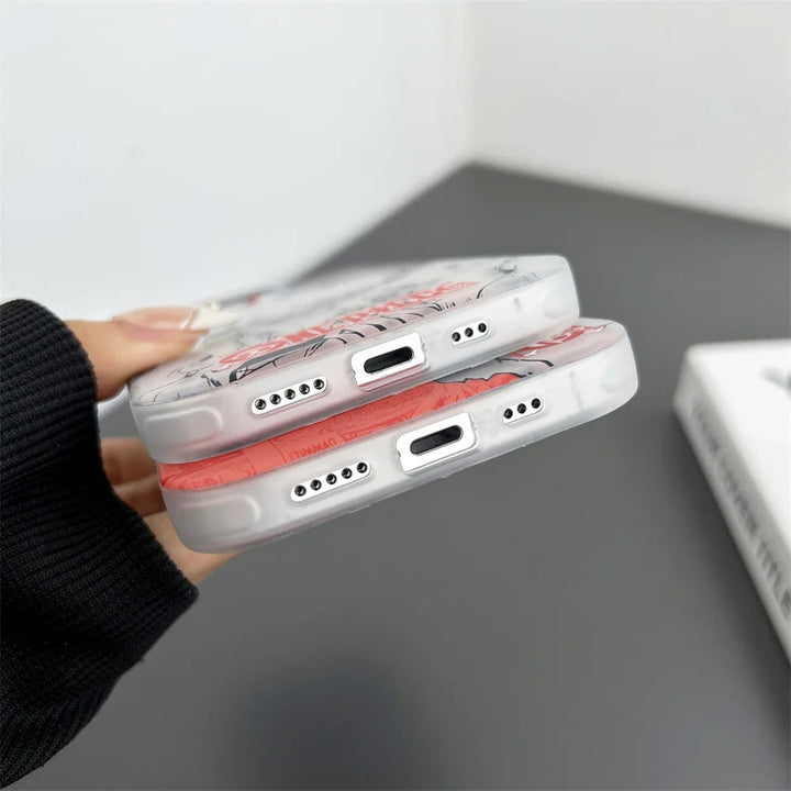 Close-up of a person's hand holding two transparent phone cases with artwork, including a Luffy design. The Luffy Gradient for iPhone case features Anti-Scratch technology and precise cutouts for charging ports and speakers.