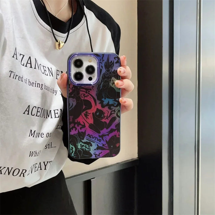 Person wearing a white and black shirt holds an iPhone with a colorful, patterned Mewtwo for iPhone case in front of a reflective surface.