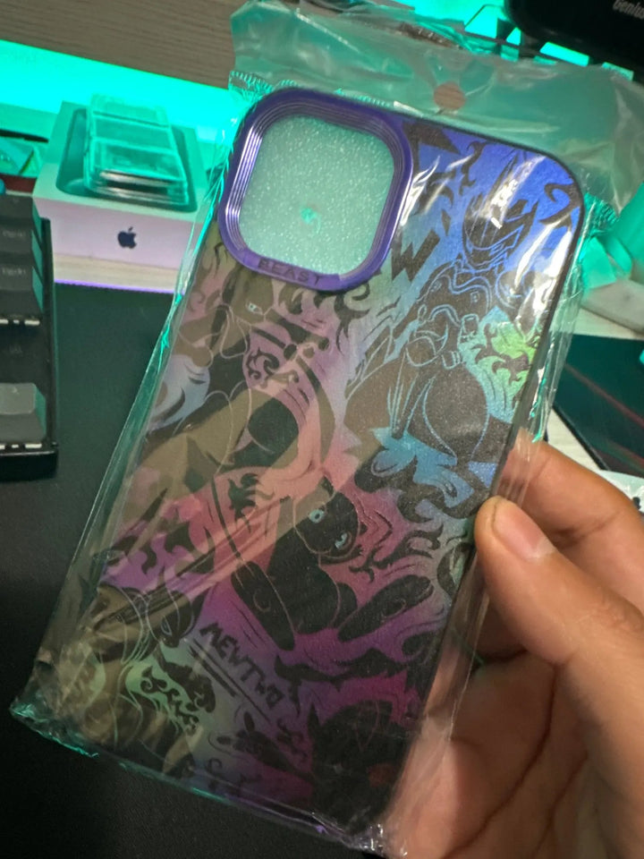 A hand holds a packaged "Mewtwo for iPhone" case, showcasing its colorful, patterned design featuring Mewtwo. The background includes a computer keyboard and an Apple product box.