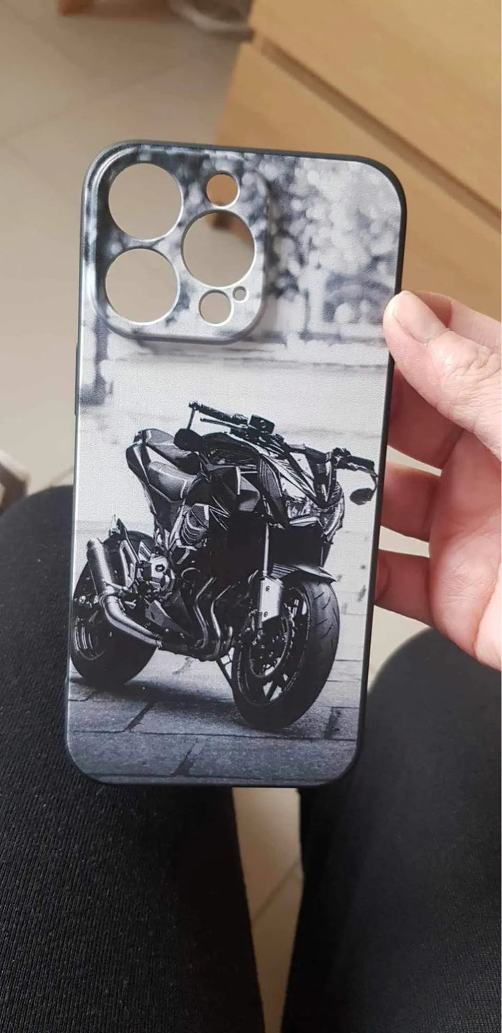 A hand holds a Motocross for iPhone phone case, featuring a lightweight design with a black and white image of a motorcycle printed on it. This anti-scratch case ensures durability while showcasing your love for motorcycles.