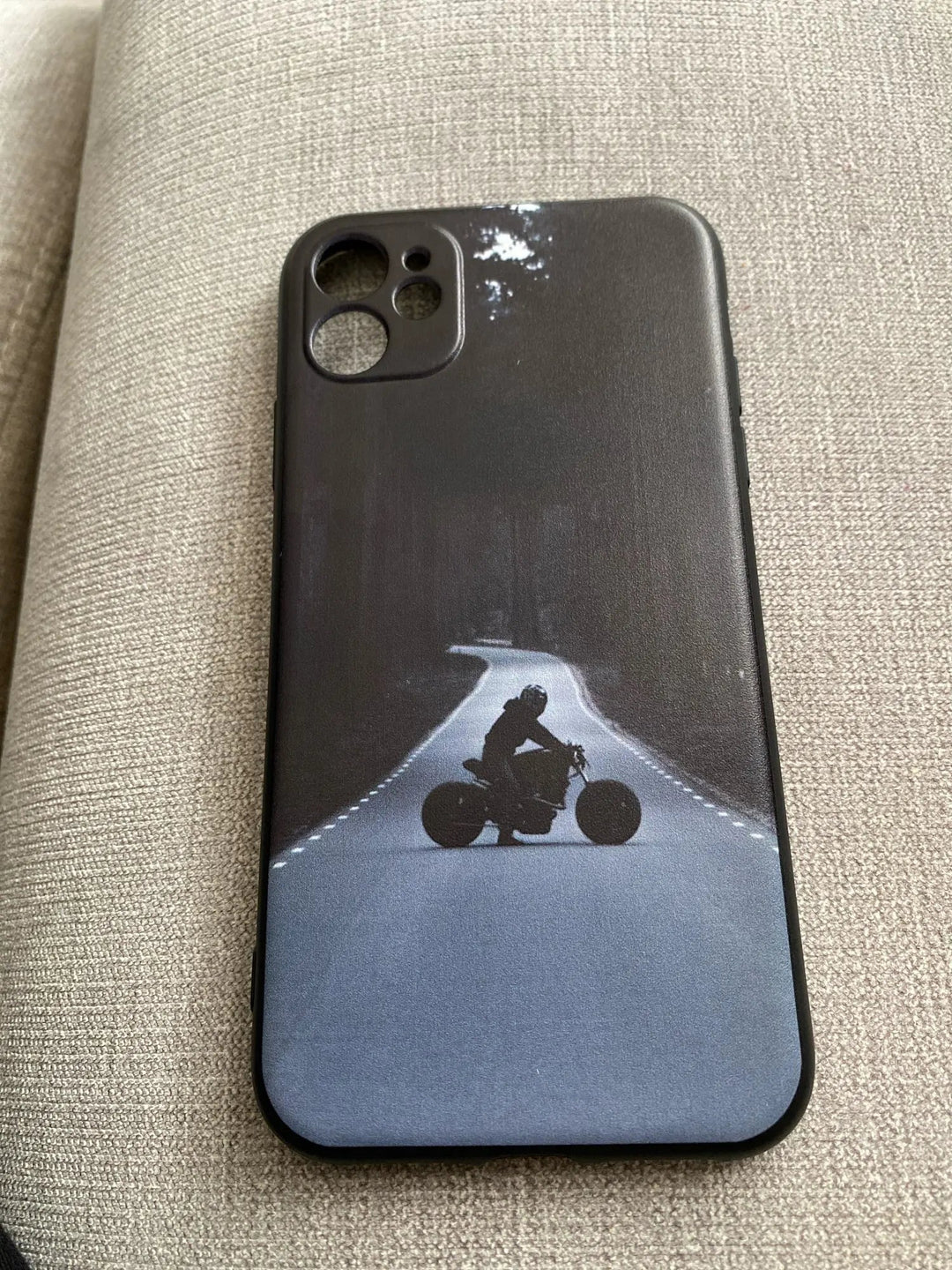 A lightweight smartphone with the Motocross for iPhone anti-scratch phone case, featuring an image of a motorcyclist riding on a tree-lined road at night.