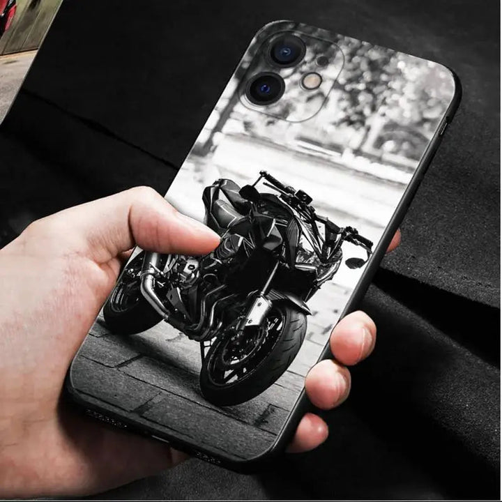 A hand holding a smartphone encased in the Motocross for iPhone, a lightweight, anti-scratch phone case featuring a black and white image of a motorcycle.