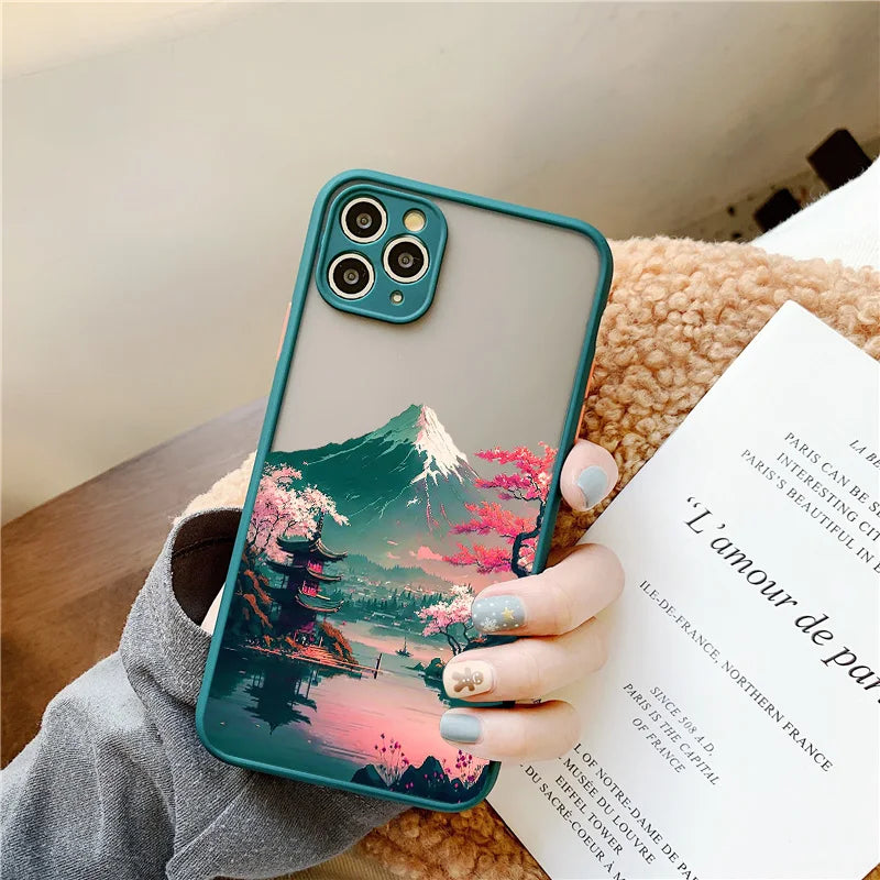 A teal phone case with a frosted back featuring a Japanese landscape with Mount Fuji, cherry blossoms, and a temple