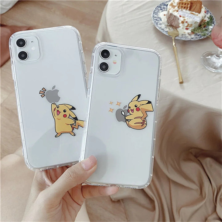 Two iPhones with Pikachu Clear Cases for iPhone featuring different Pikachu designs. The phones are held by someone over a light-colored fabric background near a table with a dessert and drink. These anti-scratch cases keep your phones looking new while showcasing your love for Pikachu.