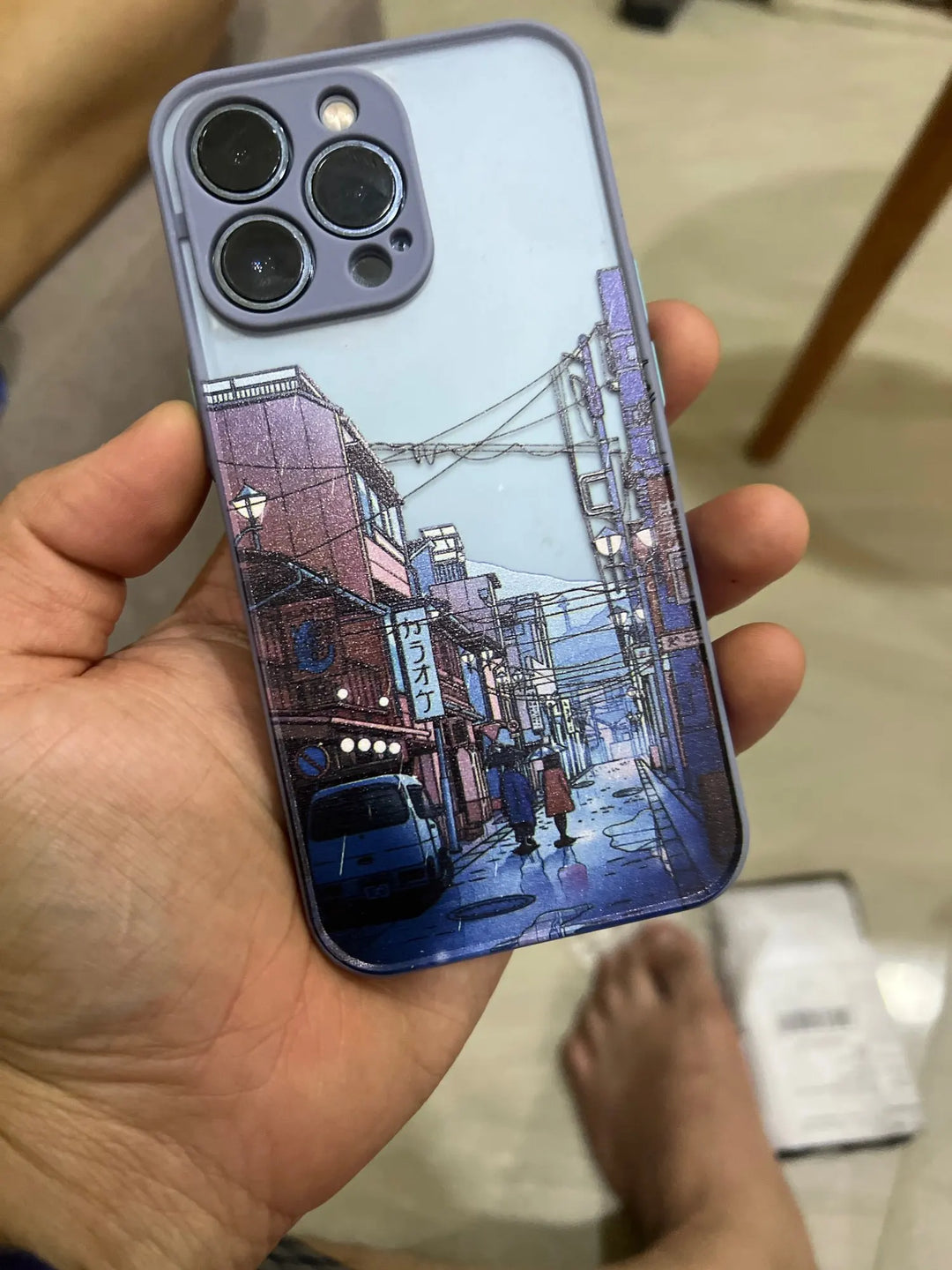 A blue phone case with a frosted back featuring a Japanese cityscape in the rain