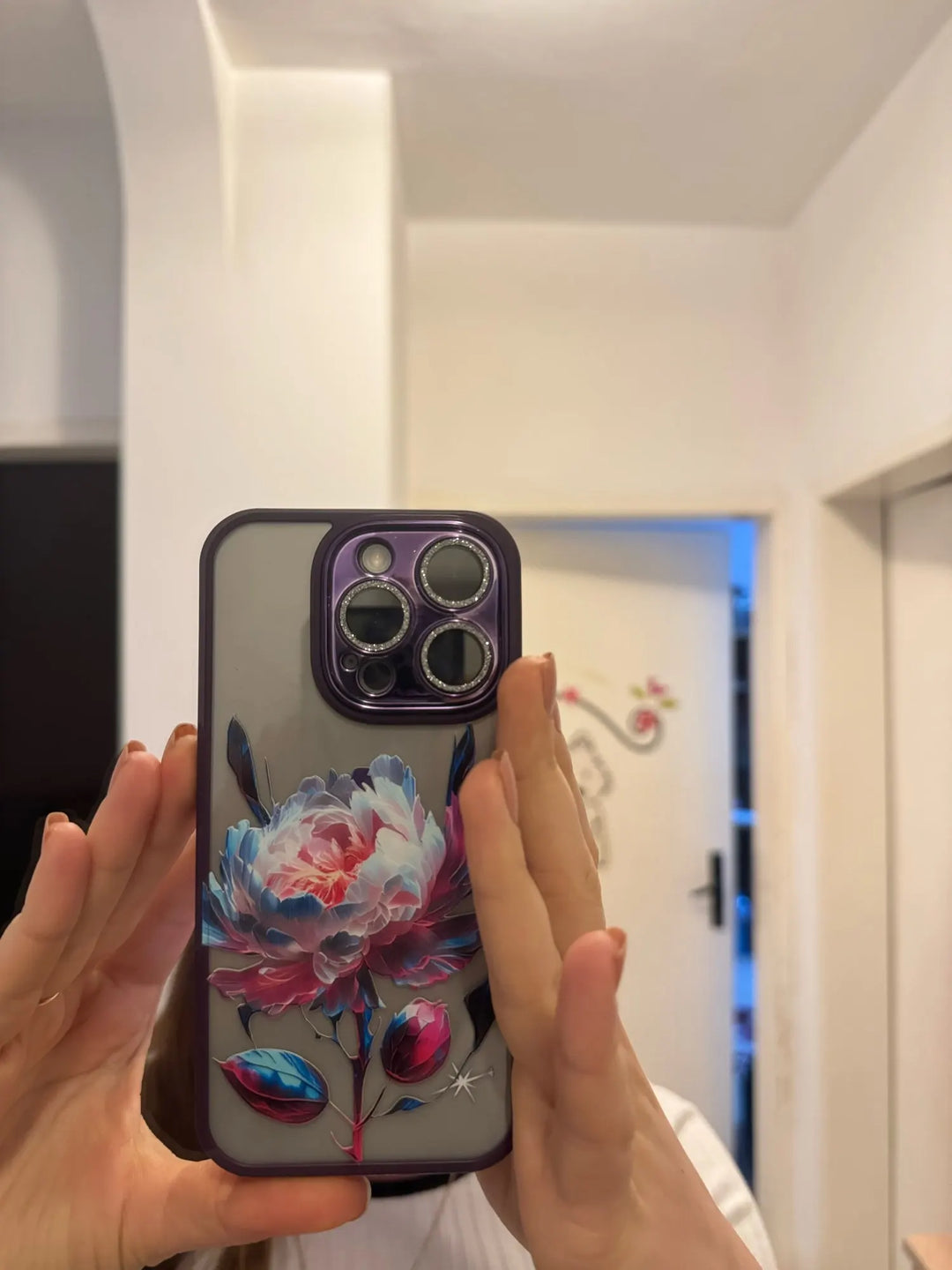 A phone case with a clear, transparent back featuring a vibrant rose design