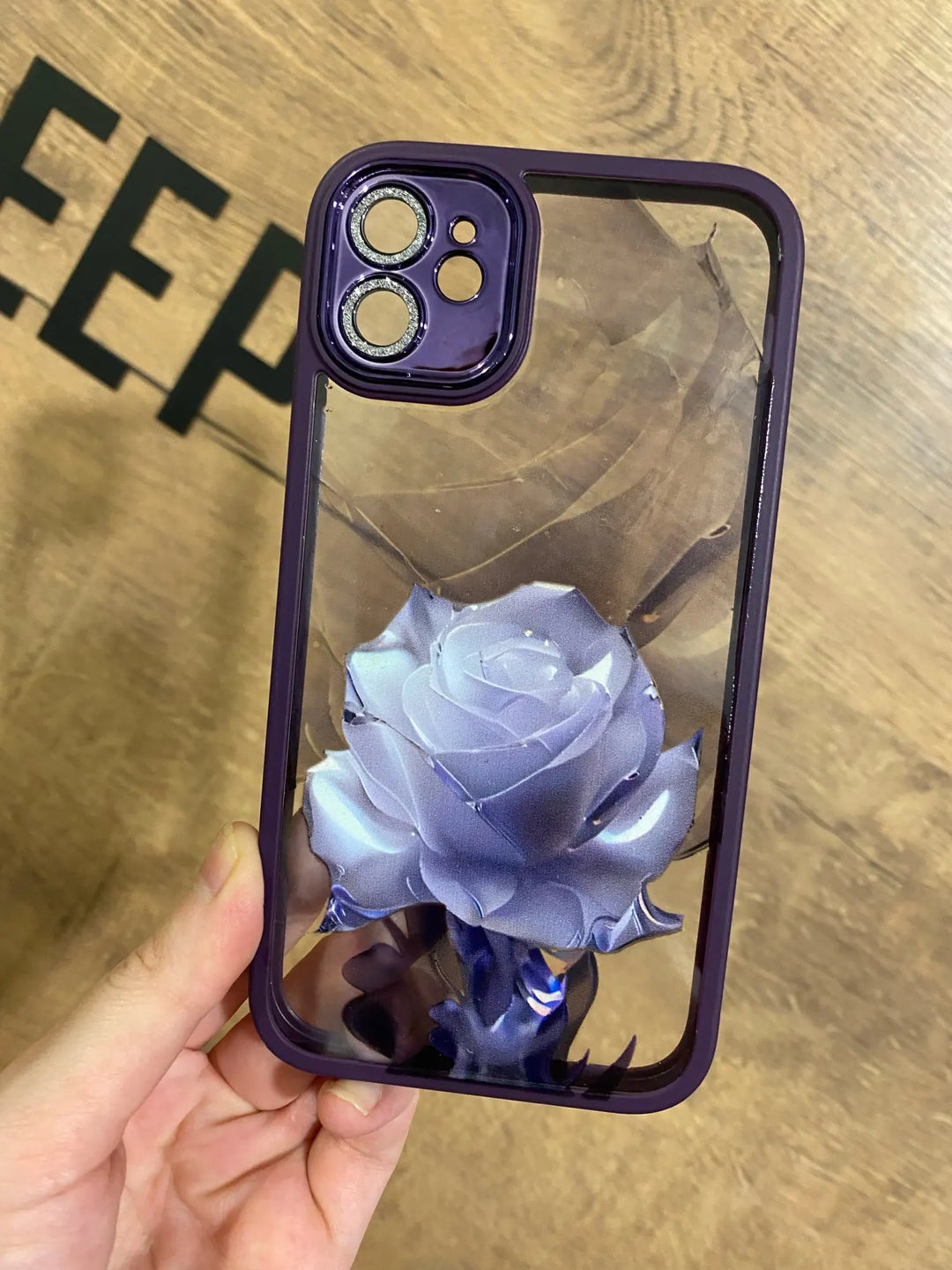 A phone case with a clear, transparent back featuring a vibrant rose design