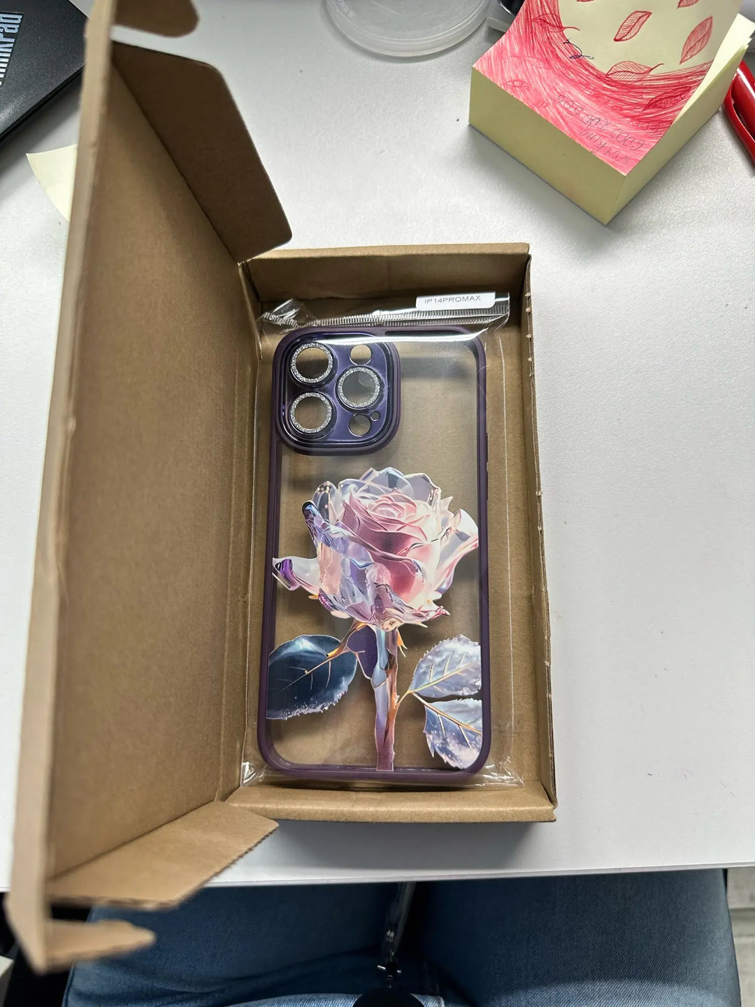 A phone case with a clear, transparent back featuring a vibrant rose design