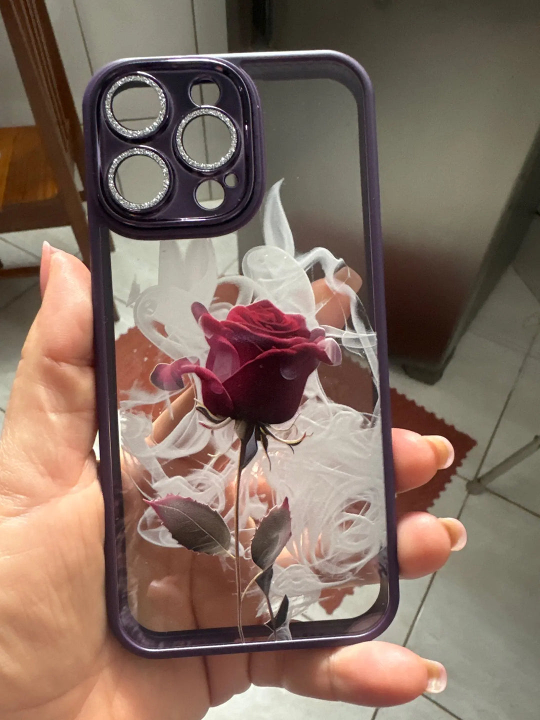 A phone case with a clear, transparent back featuring a vibrant rose design