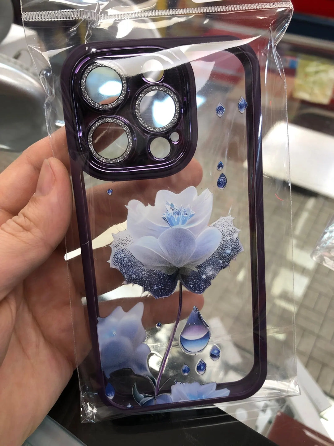 A phone case with a clear, transparent back featuring a vibrant rose design