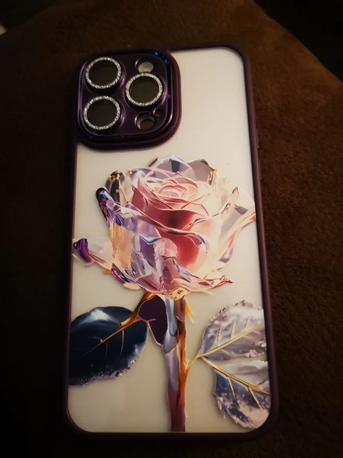 A phone case with a clear, transparent back featuring a vibrant pink and purple rose design.