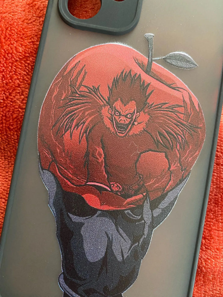 A frosted phone case with a matte finish and a red apple design featuring Ryuk, the Shinigami, from Death Note