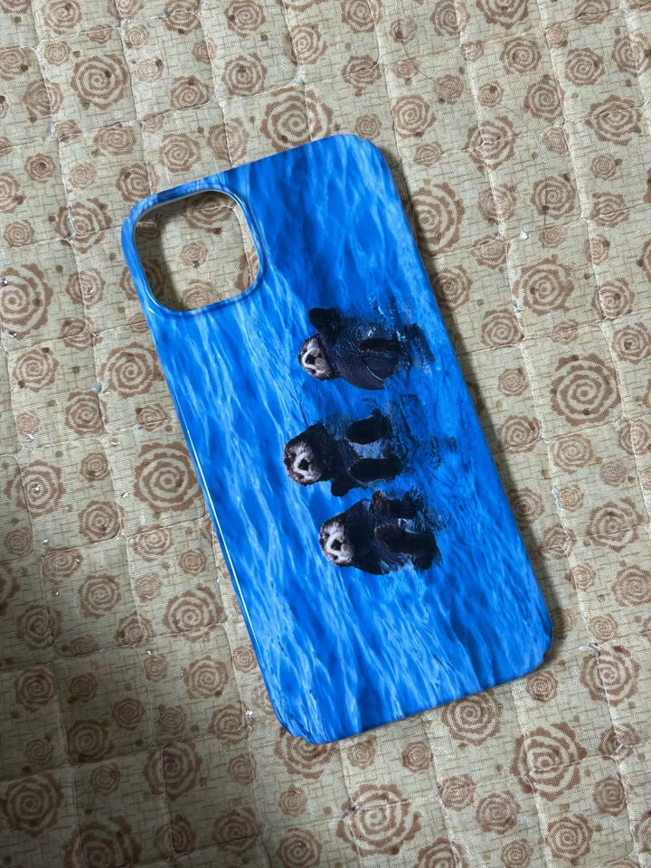 A Sea Otter Case for iPhone, featuring an image of three sea otters swimming in blue water and perfect for ocean enthusiasts and animal lovers, placed on a patterned surface.