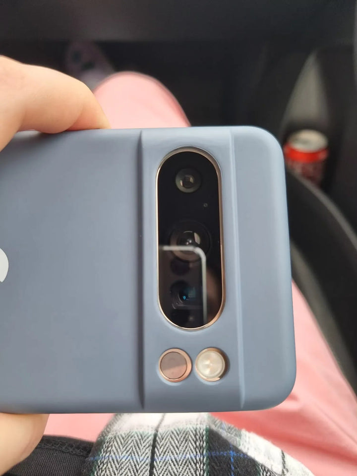 Close-up of a person holding a Google Pixel with a blue Silicone Case. The phone's camera module, featuring three lenses and a flash, is perfectly highlighted by the anti-scratch design of the case.