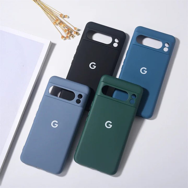 Four Silicone Cases For Google Pixel in different colors (black, blue, green, light blue) are arranged on a white surface. Each case has a "G" logo on the back and offers maximum protection with an anti-scratch finish.