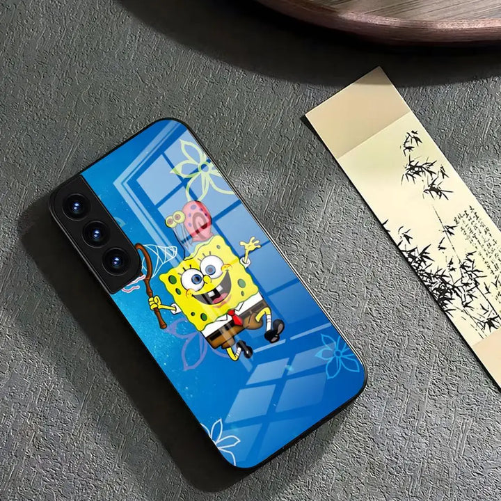 A glass phone case featuring SpongeBob SquarePants jumping for joy while holding a net