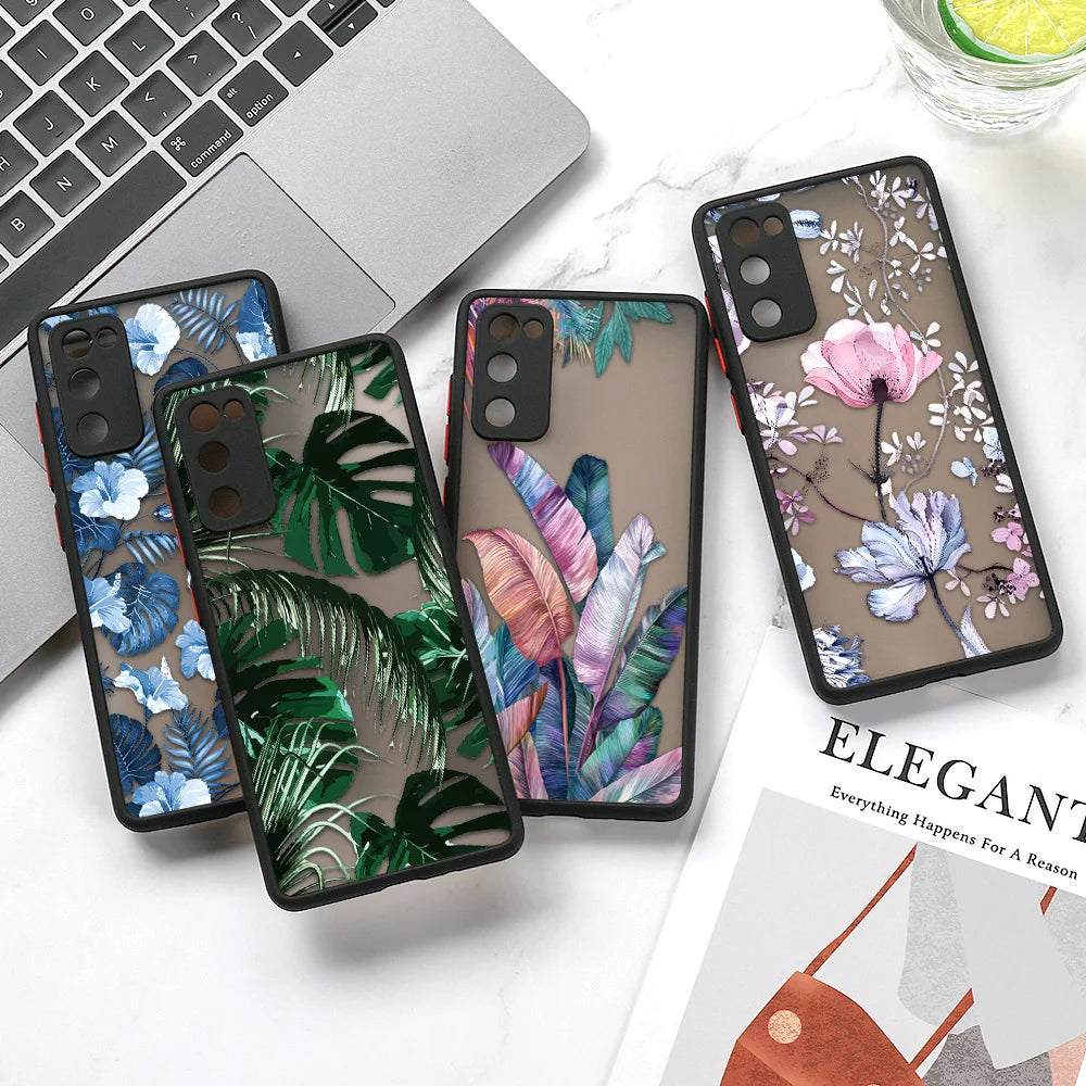 A flat lay photo of four phone cases featuring floral and tropical prints. The cases are arranged on a table 