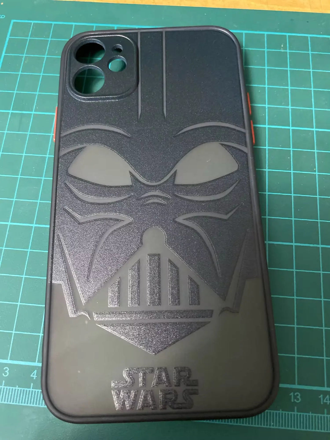 A cutting mat holds the Vader Mask for iPhone, a black phone case with anti-scratch protection that features a raised Darth Vader mask and the "Star Wars" logo at the bottom.